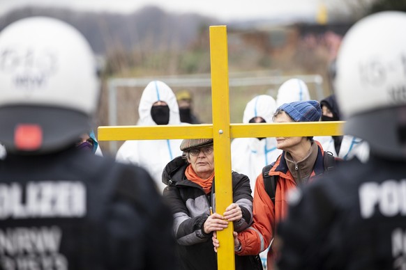 dpatopbilder - 02.01.2023, Nordrhein-Westfalen, Lützerath: Während die Polizei Vorbereitungen zur geplanten Räumung des Dorfes Lützerath trifft, stellen sich Aktivisten mit einem Holzkreuz den Polizei ...