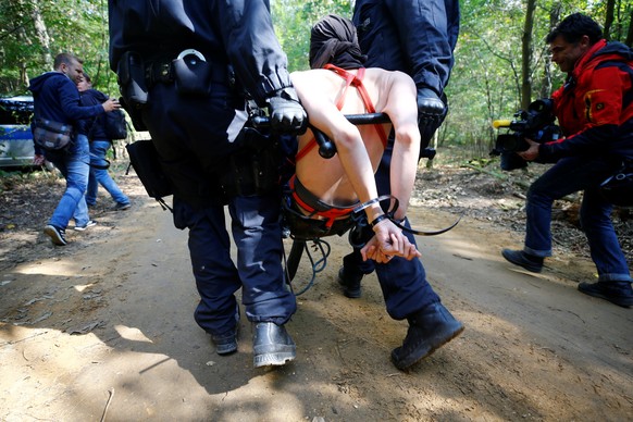 A naked female activist is carried away by police after being arrested from a tree house in the forest &quot;Hambacher Forst&quot; in Kerpen-Buir near Cologne, Germany, September 14, 2018, where prote ...
