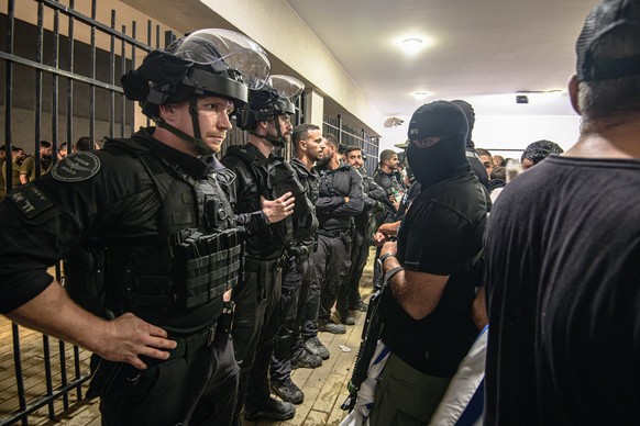 Israeli right-wing protestors broke into Beit Lid IDF base in Kfar Yona - 29 Jul 2024 Armed and masked IDF reservists from the 100 force stand in front of Israeli police officers blocking the Beit Lid ...