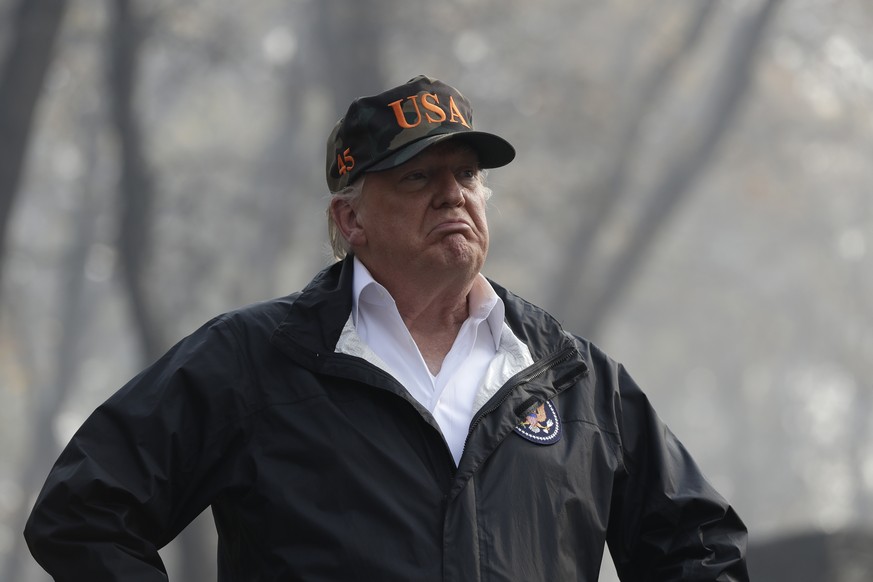 FILE - In this Nov. 17, 2018 file photo U.S. President Donald Trump visits a neighborhood impacted by the wildfires in Paradise, Calif. President Trump is threatening to withhold Federal Emergency Man ...