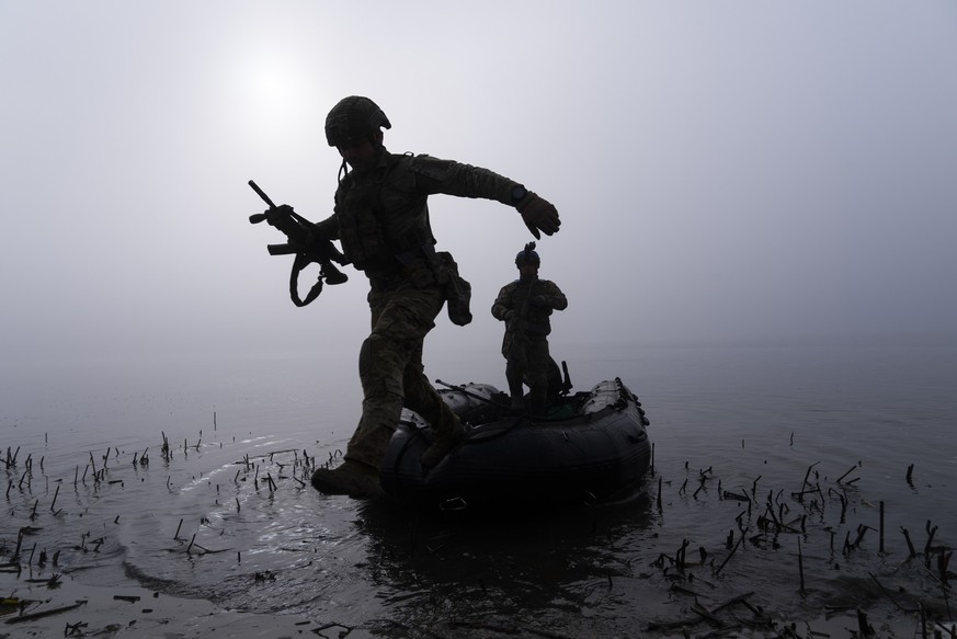 15.10.2023, Ukraine, Cherson: Ein ukrainischer Soldat springt am Ufer des Dnipro-Flusses an der Frontlinie nahe Cherson aus dem Boot. Foto: Mstyslav Chernov/AP/dpa +++ dpa-Bildfunk +++