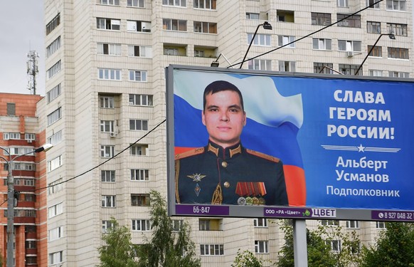 Russia Ukraine Military Operation Troops Support 8227765 30.06.2022 A billboard with the photograph of Russian serviceman Albert Usmanov, reading: Glory to the heroes of Russia is seen at the street i ...