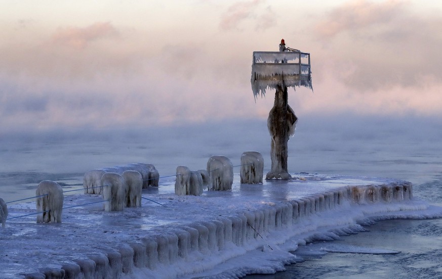 A harbor light is covered by snow and ice on the Lake Michigan at 39th Street Harbor, Wednesday, Jan. 30, 2019, in Chicago. A deadly arctic deep freeze enveloped the Midwest with record-breaking tempe ...