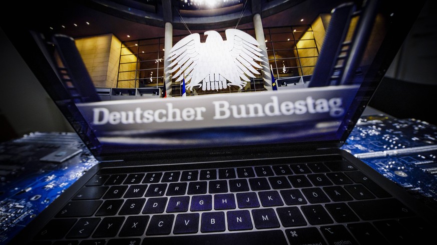 Symbolfoto zum Thema Hackerangriff auf den Bundestag . Ein Laptop, auf dessen Bildschirm ein Foto aus dem Plenum des Deutschen Bundestages zu sehen ist, steht auf einer Computerplatine. Berlin, 04.01. ...