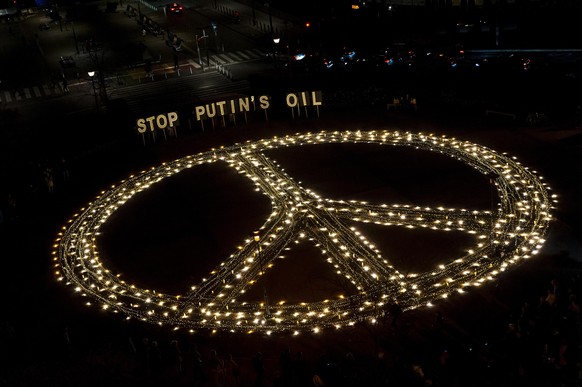 March 22, 2022, Brussels, Brussels, Belgium: Avaaz activists and young Ukrainians demonstrate with a giant peace sign and -Stop Putin&#039;s Oil- in front of the Jusutus Lispsius, the building of the  ...