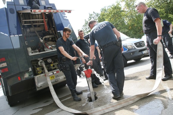 04.08.2022, Berlin: Polizisten f�llen die Tanks eines Wasserwerfers, um die Feuerwehr bei den L�scharbeiten im Grunewald zu unterst�tzen. Durch einen Waldbrand im Grunewald, der nach Angaben der Poliz ...