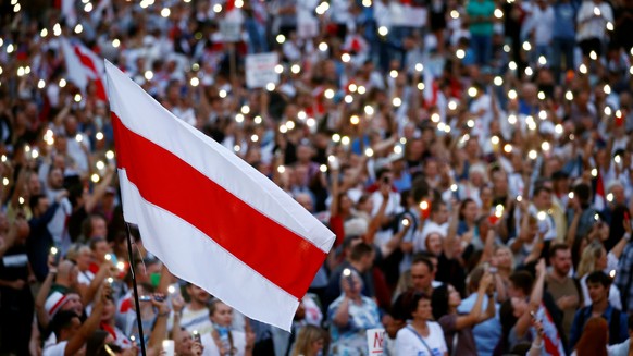 A historical white-red-white flag of Belarus is seen as people attend an opposition demonstration to protest against presidential election results, in Minsk, Belarus August 18, 2020. REUTERS/Vasily Fe ...