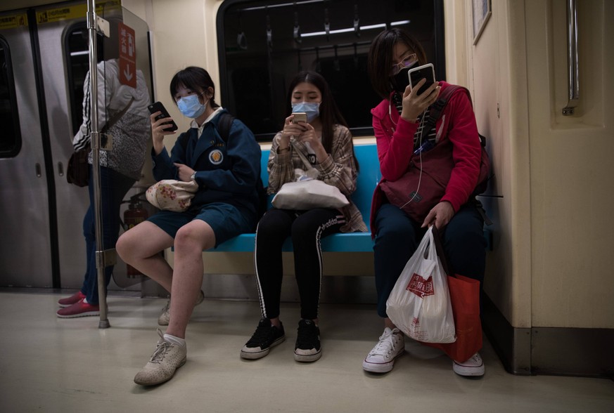 200330 -- TAIPEI, March 30, 2020 -- Passengers use mobile phones on the metro train in Taipei, southeast China s Taiwan, March 25, 2020. The total number of novel coronavirus disease COVID-19 cases in ...