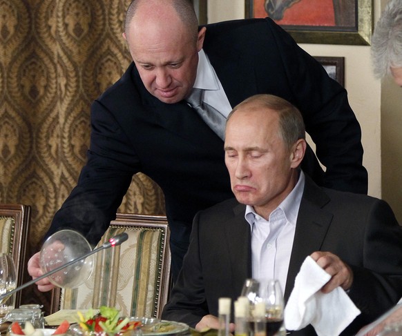FILE - Yevgeny Prigozhin, top, serves food to then-Russian Prime Minister Vladimir Putin at Prigozhin&#039;s restaurant outside Moscow, Russia on Nov. 11, 2011. Prigozhin, the millionaire owner of the ...