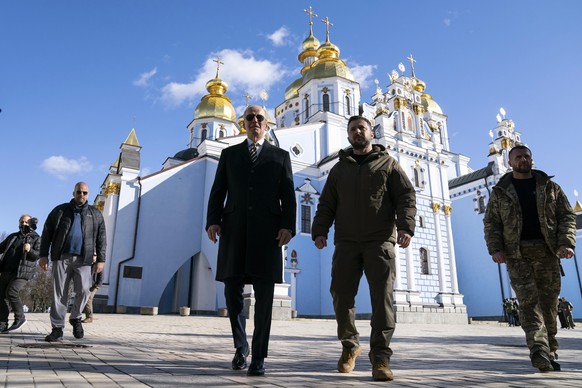 20.02.2023, Ukraine, Kiew: Joe Biden (l), Präsident der USA, geht neben Wolodymyr Selenskyj, Präsident der Ukraine, an der Kathedrale mit der goldenen Kuppel von St. Michael. Biden ist zu einem Besuch ...