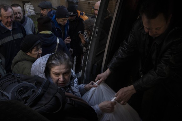 Ukraine-Konflikt, Eindr�cke aus Sjewjerodonezk April 7, 2022, Severodontesk, Ukraine: A woman grabs grocery bags offered by a volunteer from the Czech non-governmental organization SOS Vostok in Sever ...