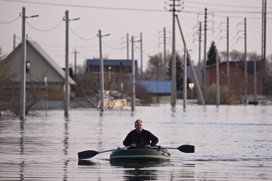 Russia Kurgan Floods 8666081 20.04.2024 A man sails on a rubber boat through a flooded street in the Kurgan region, Russia. Water levels in the Tobol River in the Kurgan region exceeded 1,000 centimet ...
