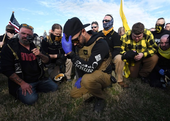 December 12, 2020, Washington, DC, USA: ENRIQUE TARRIO, leader of far-right group the Proud Boys pray as supporters of President Donald Trump rally to challenge election results as opposing views clas ...