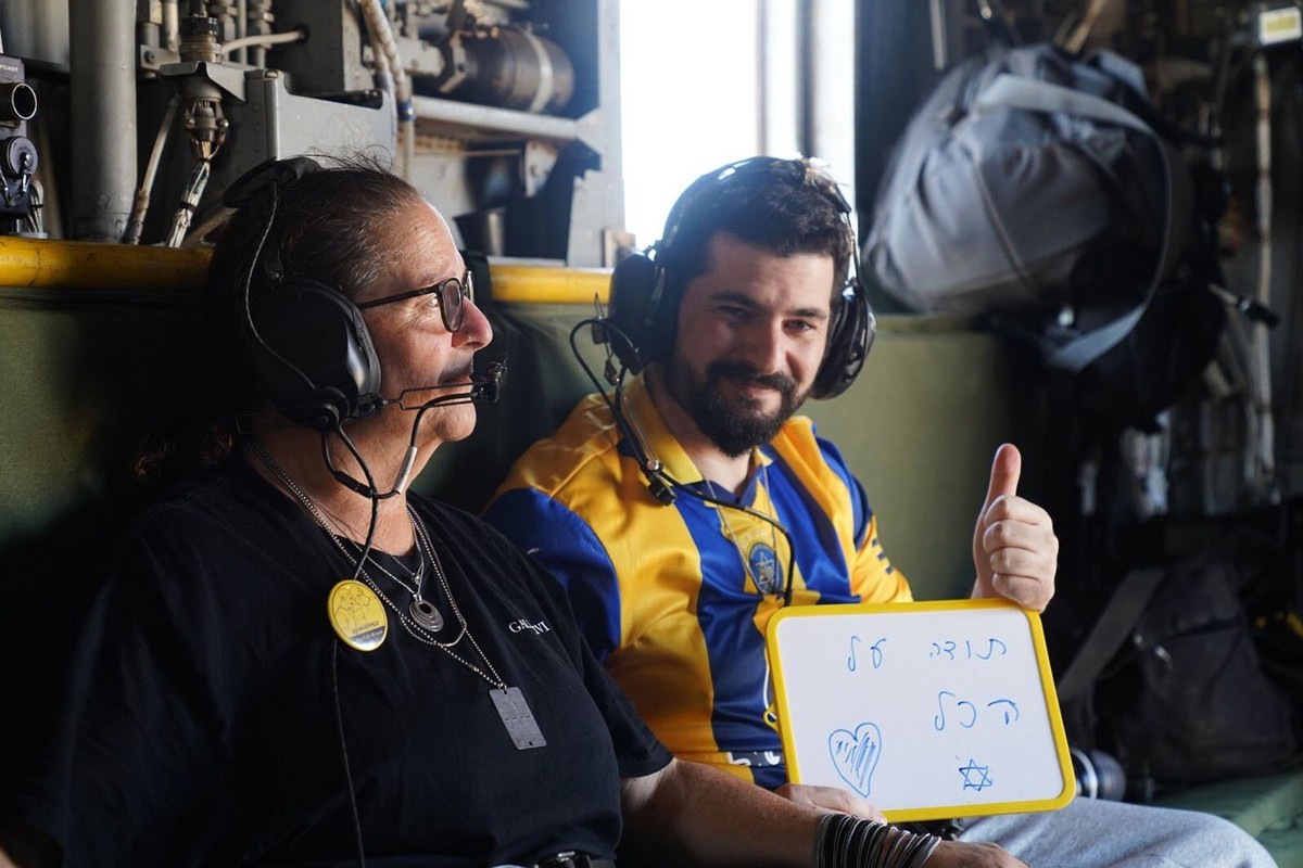 Ziv Berman, carries a placard reading in Hebrew: &quot;Thank you for everything,&quot; as he sits onboard an IAF helicopter en route to the hospital after being released from Hamas captivity, on Monda ...