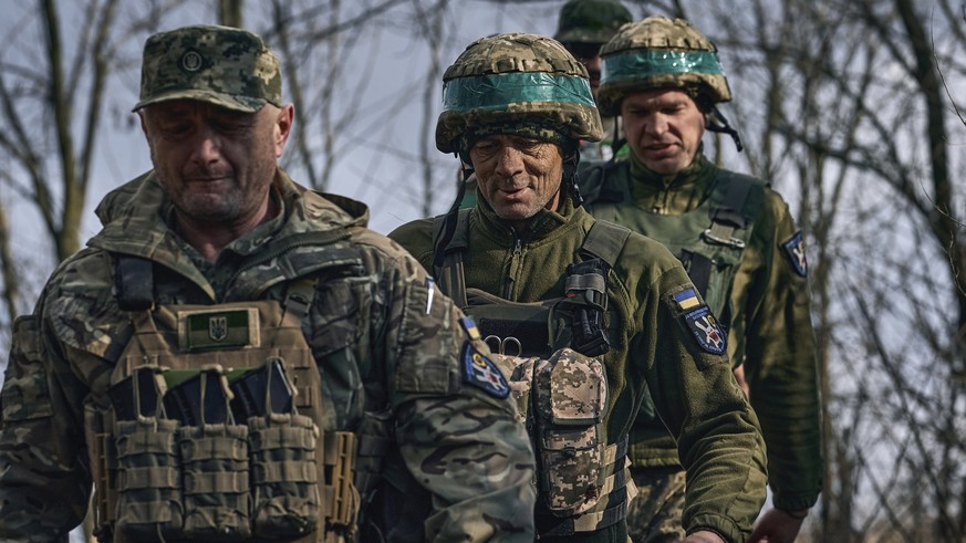 27.03.2023, Ukraine, Bachmut: Ukrainische Soldaten der 28. Brigade gehen gemeinsam an ihrer Position an der Frontlinie in der Nähe von Bachmut in der Region Donezk. Foto: Libkos/AP +++ dpa-Bildfunk ++ ...