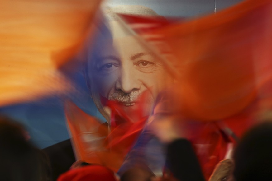 FILE - Supporters of President Recep Tayyip Erdogan wave flags in front of his picture in Istanbul, on March 31, 2019. Erdogan, who is seeking a third term in office as president in elections in May,  ...