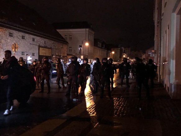 Die Polizisten sperren eine Straße.