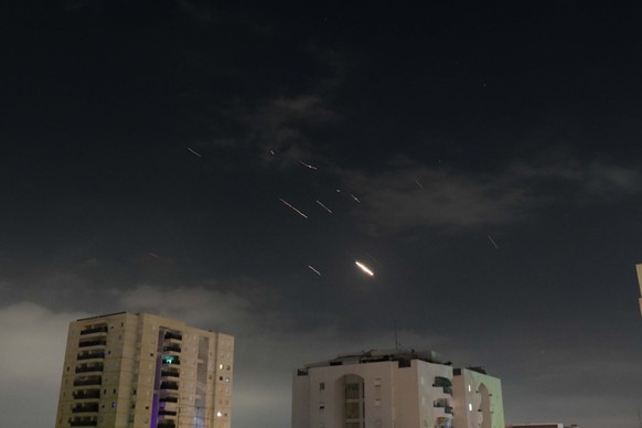 14.04.2024, Israel, Tel Aviv: Flammen von Explosionen erscheinen am Himmel �ber Tel Aviv, w�hrend Israels Raketenabwehrsystem Raketen und Drohnen aus dem Iran abf�ngt. (zu dpa: �G7-Gruppe verurteilt i ...