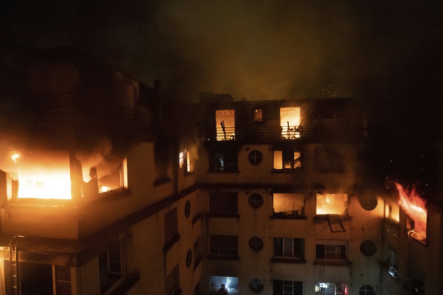 In this image provided on Tuesday, Feb. 5, 2012 by the Brigade de Sapeurs-Pompiers de Paris (Paris Fire Brigade) a fire rages through the top floors of an apartment building in Paris, France. The Pari ...