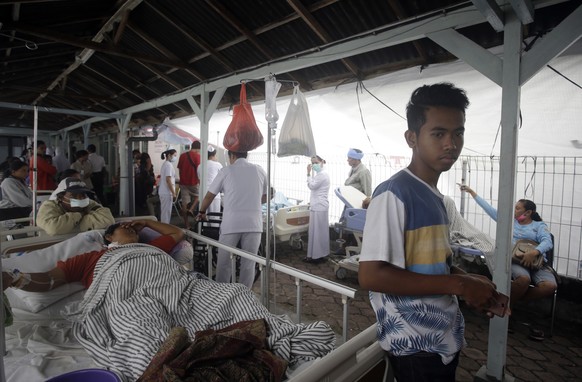 Patients are evacuated outside a hospital following an earthquake in Bali, Indonesia, Monday, Aug. 6, 2018. A powerful earthquake struck the Indonesian tourist island of Lombok on Sunday, shaking neig ...