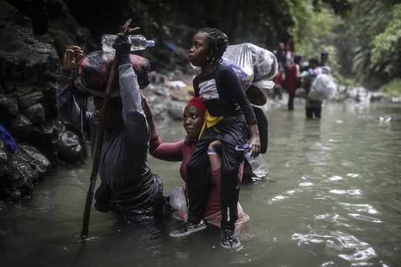 ARCHIV - 09.05.2023, Kolumbien, Darien Gap: Menschen aus Haiti waten durch Wasser, während sie den Darién-Dschungel von Kolumbien nach Panama überqueren, in der Hoffnung, die USA zu erreichen.

Die Me ...