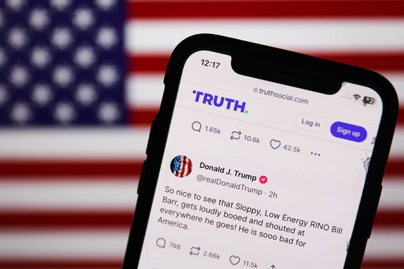 Donald Trump Truth Social Account Photo Illustrations American flag displayed on a screen and Donald Trump account on Truth Social displayed on a phone screen are seen in this illustration photo taken ...