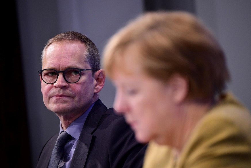 BERLIN, GERMANY - NOVEMBER 25: Berlin&#039;s Mayor Michael Mueller (L) and German Chancellor Angela Merkel (R) during a press conference after a virtual meeting with leaders of Germany&#039;s 16 state ...