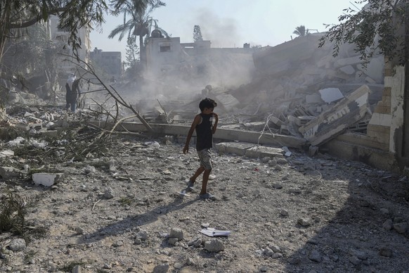 A Palestinian boy walks past the rubble of a school destroyed in an Israeli airstrike on Deir al-Balah, central Gaza Strip, Saturday, July 27, 2024. (AP Photo/Abdel Kareem Hana)