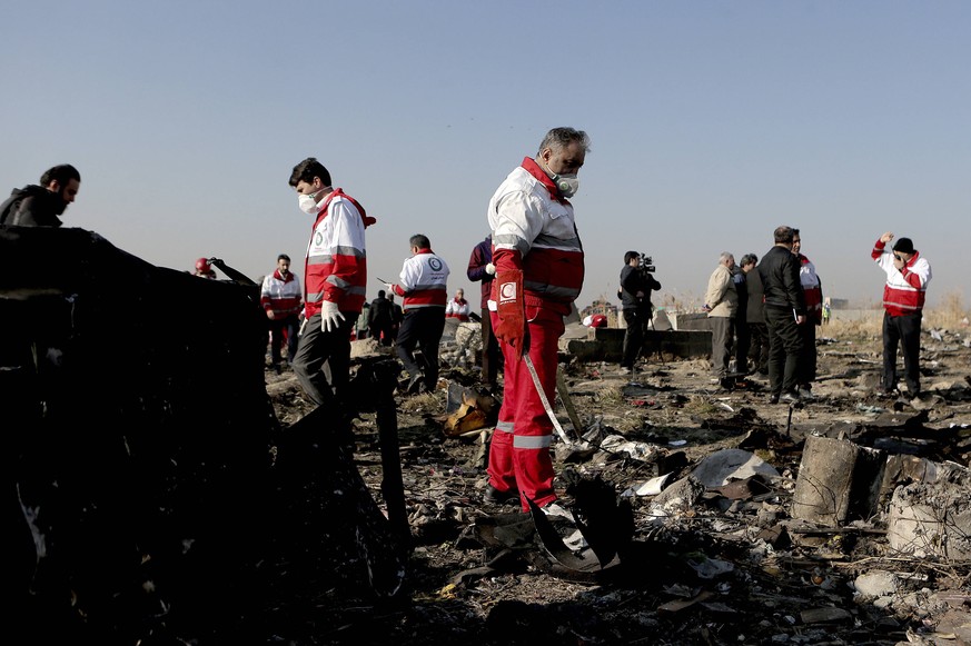 Helfer suchen in den Trümmern der abgeschossenen Boeing nahe Teheran. 