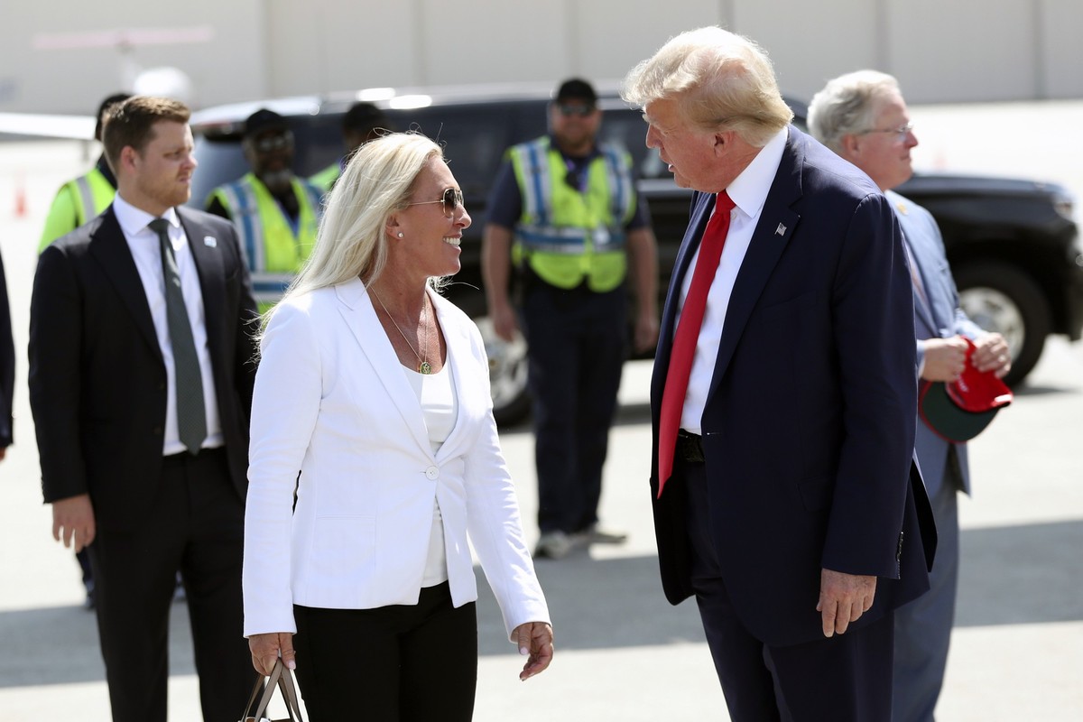Former President Donald Trump is greeted by Rep. Majorie Taylor Greene, R-Ga., as he arrives at Atlantic Aviation CHS in North Charleston, S.C., Saturday, Sept. 25, 2023. (AP Photo/Artie Walker Jr.)