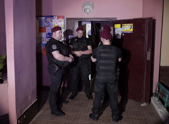 Ukrainian police officers guard in the entrance to a house where Russian journalist Arkady Babchenko was shot and died of his wounds in an ambulance, in Kiev, Ukraine May 29, 2018. REUTERS/Valentyn Og ...