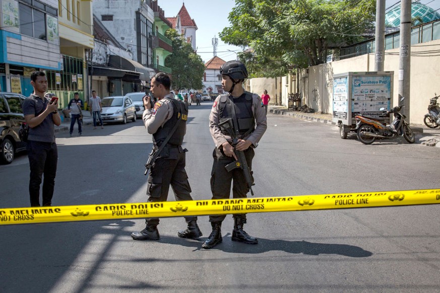 SURABAYA, INDONESIA - MAY 14: Indonesian police stand guard outside the Surabaya police station following another explosion on May 14, 2018 in Surabaya, Indonesia. At least 10 people were injured on M ...