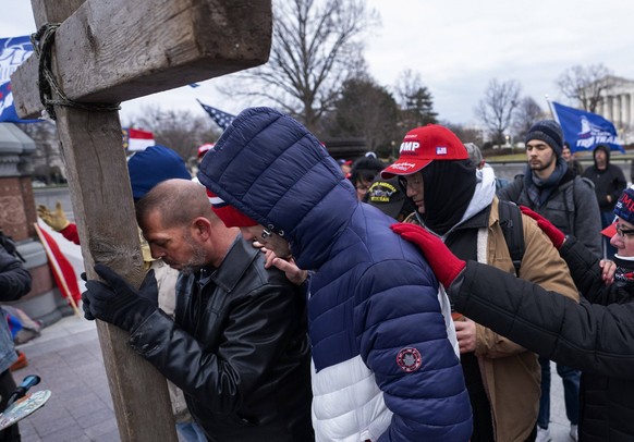 President Donald Trump supporters pray outside of the U.S. Capitol Building as they gather to protest against the Electoral College vote certification that would certify President-elect Joe Biden as t ...