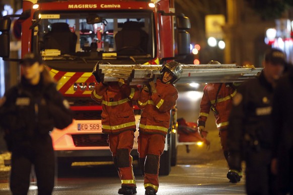 Firefighters leave the scene of a fire in Paris, Tuesday, Feb. 5, 2019. A fire in a Paris apartment building early Tuesday killed seven people and sent residents fleeing to the roof or climbing out th ...