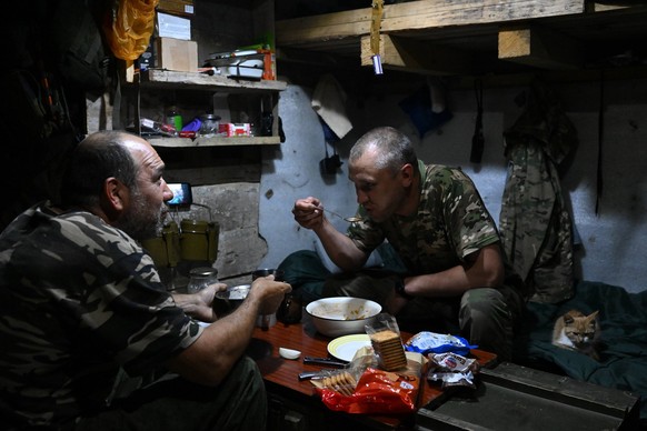 Russia Ukraine Military Operation Volunteer Unit 8477159 12.07.2023 Servicemen of the Bars-10 Russian volunteer unit have their lunches in a shelter at a position in the course of Russia s military op ...