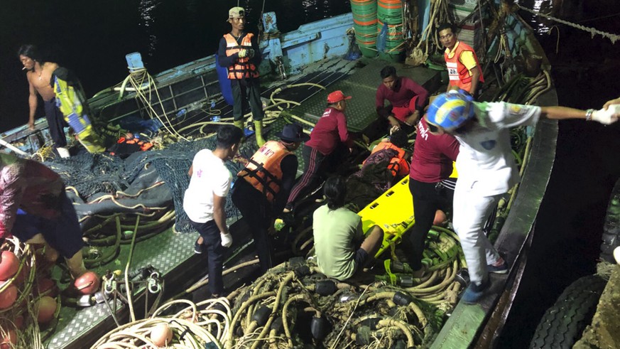 In this photo released by the Thailand Royal Police, rescued tourists from a boat that sank are helped onto a pier from a fishing boat Thursday, July 5, 2018, on the island of Phuket, southern Thailan ...