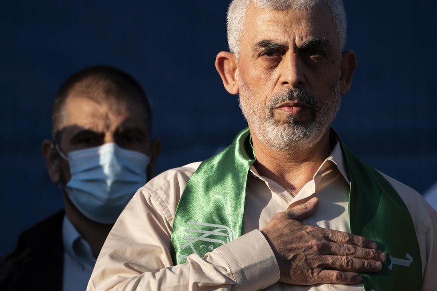 FILE - Yahya Sinwar, Palestinian leader of Hamas in the Gaza Strip, places his hand over his heart on stage after greeting supporters at a rally on May 24, 2021, in Gaza City, the Gaza Strip. (AP Phot ...