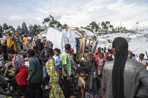 People gather at the side of an explosion in a refugee camp on the outskirts of Goma, Democratic Republic of the Congo, Friday, May, 3, 2024. The Congolese army says a bomb at a refugee camp in easter ...