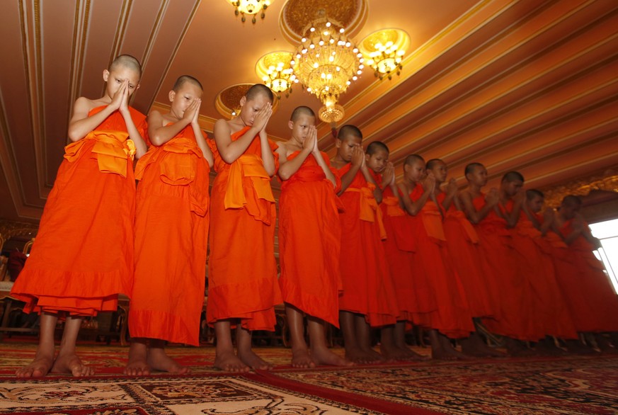 Members of Wild Boars soccer team pray during a ceremony marking the completion of serving a novice Buddhist monks following their dramatic rescue from a cave in Mae Sai district, Chiang Rai province, ...