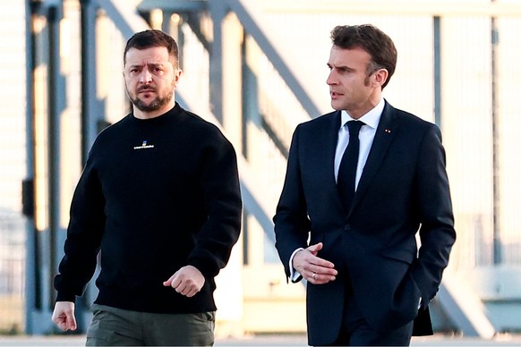 09.02.2023, Frankreich, Paris: Emmanuel Macron (r), Präsident von Frankreich, geht neben Wolodymyr Selenskyj, am Militärflughafen Villacoublay. Der französische Präsident Macron und der ukrainische Pr ...