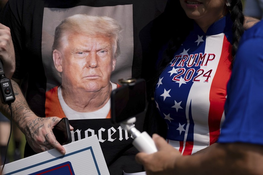 Supporters of former President Donald Trump and journalists gather in front of the Fulton County Jail in Atlanta on Thursday, Aug. 24, 2023. Trump surrendered Thursday on charges that he illegally sch ...