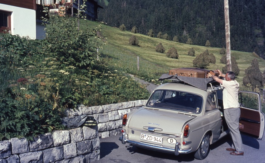 Mann beim Beladen seines Autos GER 640801, Mann beim Beladen seines Autos