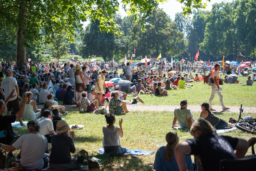 08.08.2020, Baden-Württemberg, Stuttgart: Teilnehmer sitzen während einer Kundgebung der Initiative «Querdenken 711» im unteren Schlossgarten, die sich gegen die Corona-Maßnahmen richtet, im Schatten. ...