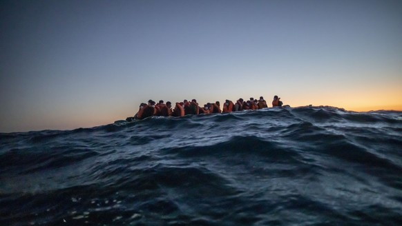 ARCHIV - 12.02.2021, ---: Migranten aus verschiedenen afrikanischen Nationen warten in einem Boot auf Helfer der spanischen NGO