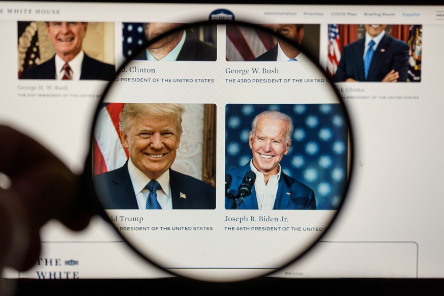 Joe Biden the president of United States of America and Donald Trump on the news. Looking through magnifying glass