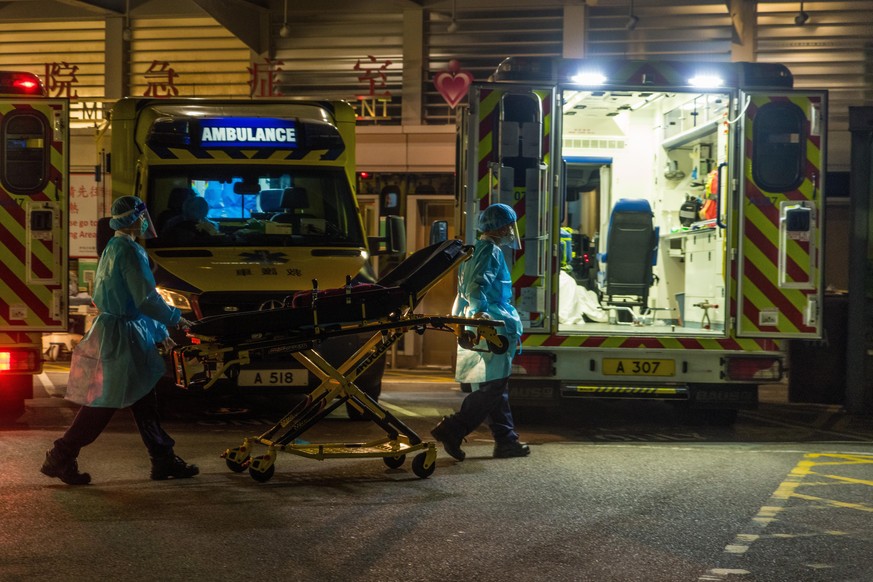 Paramedics in PPE bring back a stretcher to their ambulance, in Hong Kong, China, on March 04, 2022. (Photo by Marc Fernandes/NurPhoto)