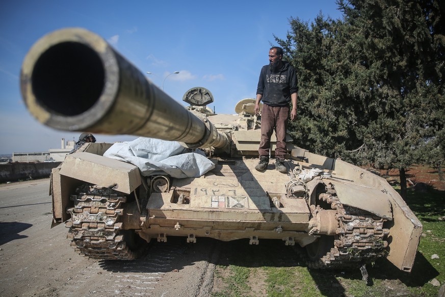Syrien, Sarakib: Ein Kämpfer der Nationalen Befreiungsfront (NFL) steht auf einem Panzer der syrischen Regierungstruppen.