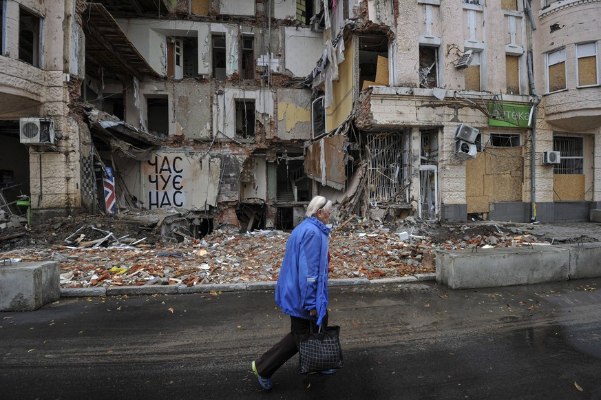 September 18, 2022, Kharkiv, Ukraine: A woman walks next to a destroyed building that was damaged as a result of the shelling of the Russian army in Kharkiv. Russia invaded Ukraine on 24 February 2022 ...