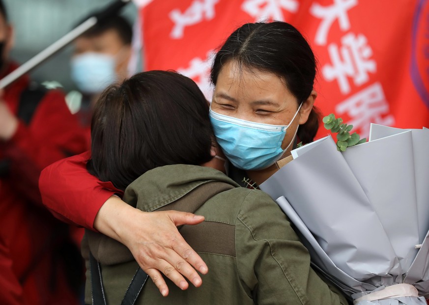 (200407) -- WUHAN, April 7, 2020 () -- A medical worker and a local resident hug each other at Wuhan Railway Station in Wuhan, central China's Hubei Province, April 7, 2020. The last batch of 186 medi ...
