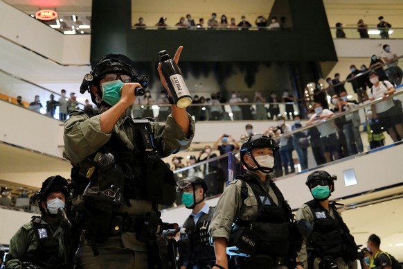 A riot police wearing face mask to avoid the spread of the coronavirus disease (COVID-19) holds a pepper spray as he tries to disperse anti-government protesters as they stage a rally at a shopping ma ...